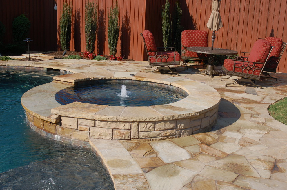 Design ideas for a mid-sized country backyard round pool in Dallas with a hot tub and natural stone pavers.