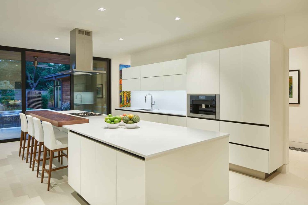 Inspiration for a modern u-shaped separate kitchen in Dallas with an undermount sink, flat-panel cabinets, white cabinets, white splashback, ceramic splashback, stainless steel appliances, limestone floors, with island and white floor.