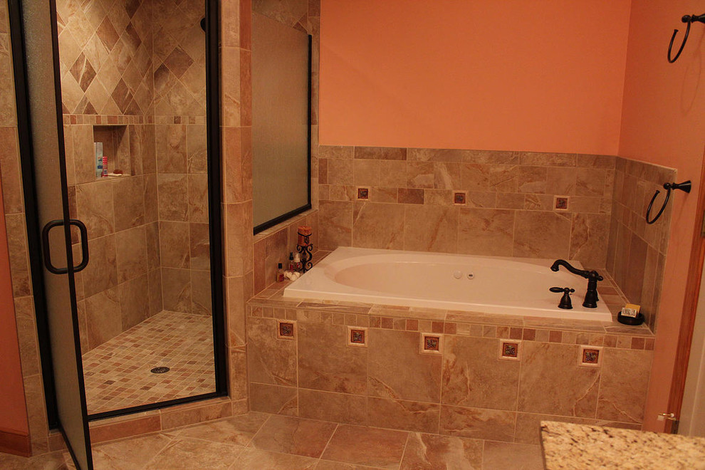 This is an example of a master bathroom in DC Metro with a drop-in tub, a corner shower, orange walls and ceramic floors.