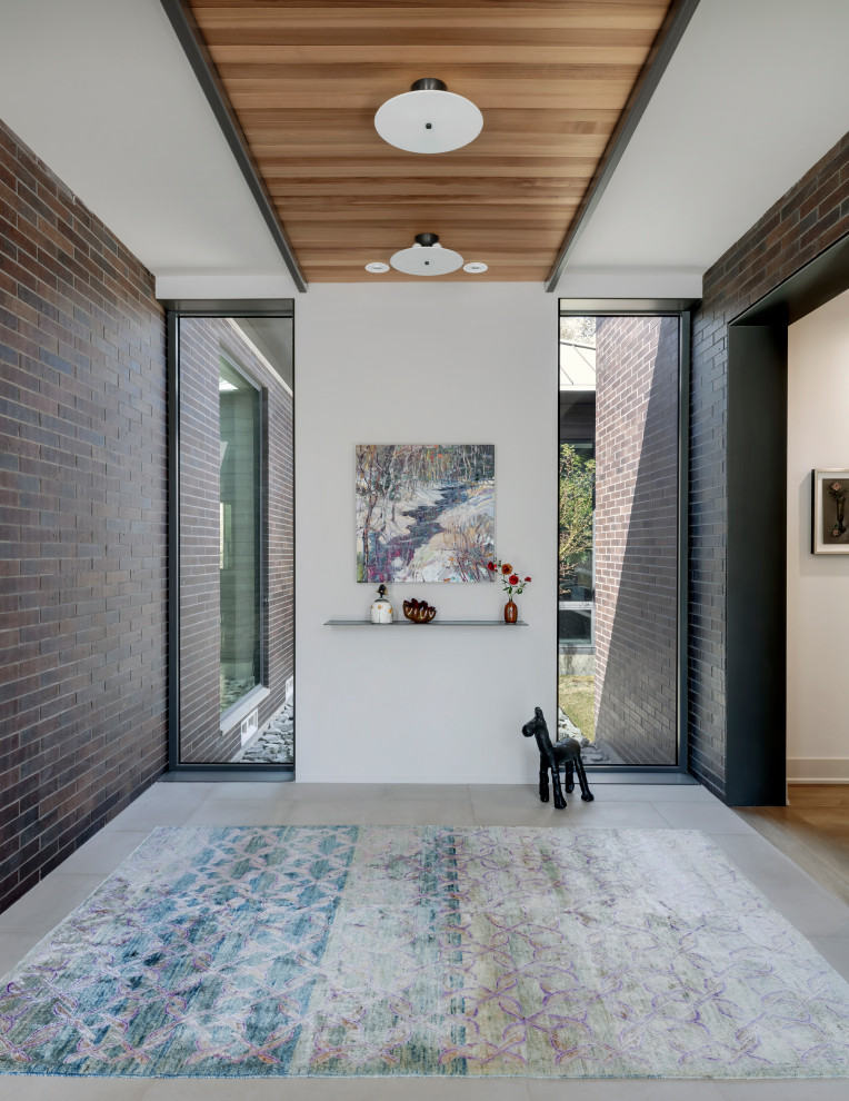 Idée de décoration pour un hall d'entrée minimaliste avec un mur blanc, un sol en calcaire, une porte simple, une porte en bois brun, un sol blanc, un plafond en bois et un mur en parement de brique.
