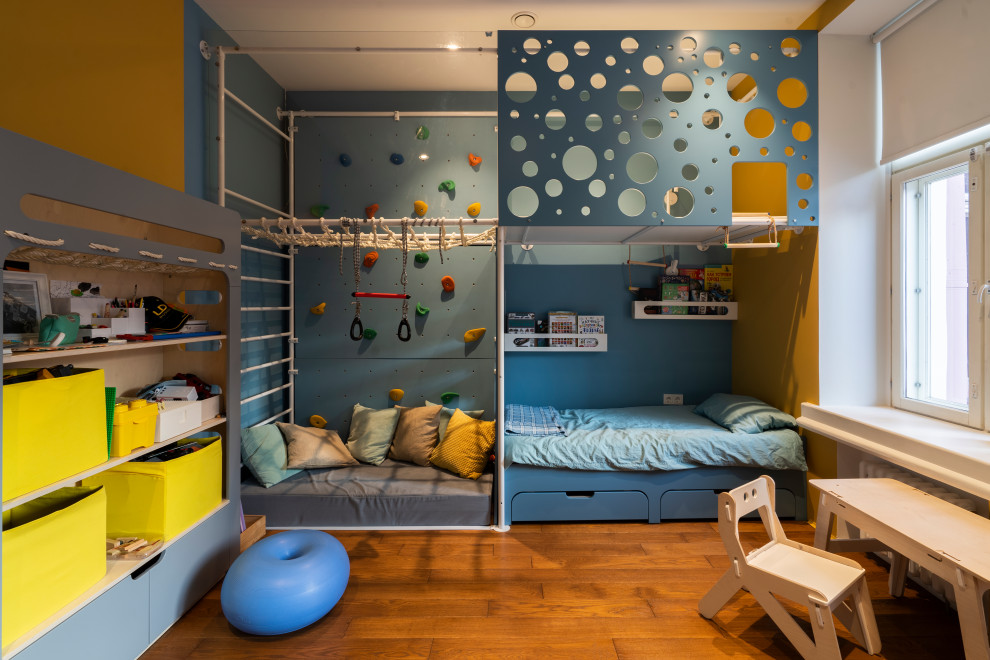 Idéer för ett mellanstort industriellt småbarnsrum kombinerat med lekrum, med vita väggar och mellanmörkt trägolv