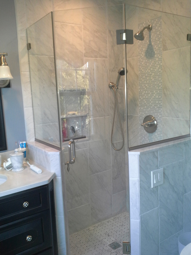 This is an example of a small traditional 3/4 bathroom in Philadelphia with an undermount sink, raised-panel cabinets, black cabinets, engineered quartz benchtops, a corner shower, a two-piece toilet, white tile, porcelain tile, grey walls and porcelain floors.