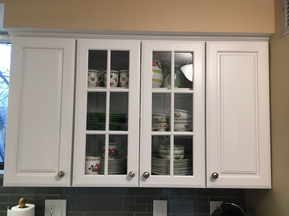 Inspiration for a transitional u-shaped medium tone wood floor kitchen remodel in Boston with a drop-in sink, raised-panel cabinets, white cabinets, granite countertops, green backsplash, glass tile backsplash, white appliances, a peninsula and green countertops