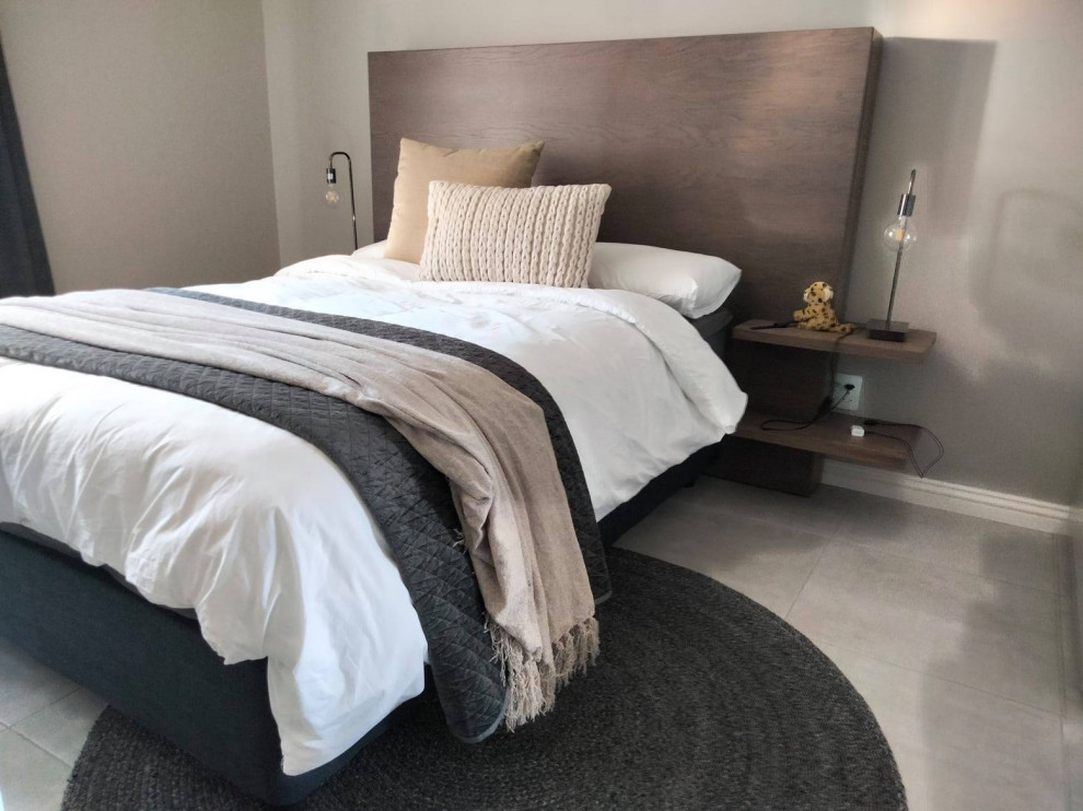 Esempio di una piccola camera da letto minimal con pareti beige, pavimento con piastrelle in ceramica e pavimento grigio