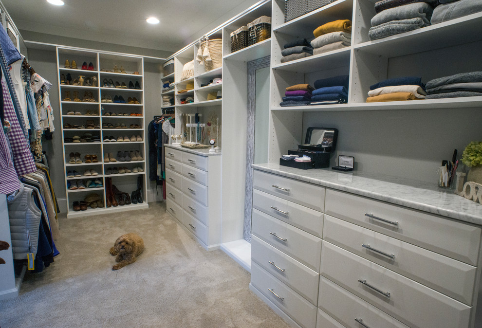 Large traditional walk-in wardrobe in Charlotte with raised-panel cabinets, white cabinets, carpet and grey floor.