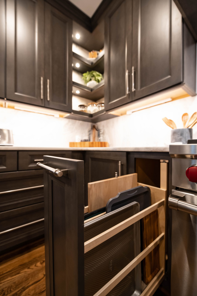 Mid-sized transitional l-shaped medium tone wood floor and brown floor enclosed kitchen photo in Birmingham with a double-bowl sink, recessed-panel cabinets, dark wood cabinets, marble countertops, white backsplash, marble backsplash, stainless steel appliances, a peninsula and white countertops