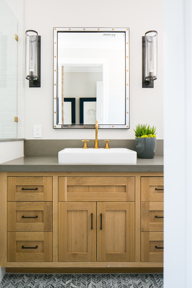 Photo of a transitional bathroom in Orange County with shaker cabinets, medium wood cabinets, white walls, mosaic tile floors, a vessel sink, grey floor and grey benchtops.