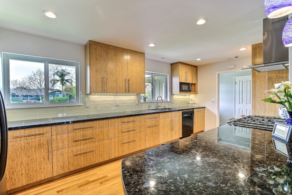 Photo of a mid-sized contemporary single-wall kitchen in San Francisco with an undermount sink, flat-panel cabinets, light wood cabinets, granite benchtops, glass tile splashback, stainless steel appliances, light hardwood floors and no island.