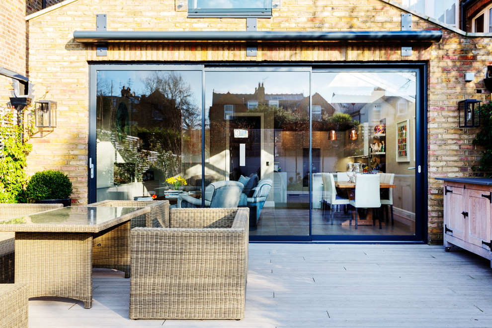 Inspiration for a mid-sized transitional patio in London with decking.