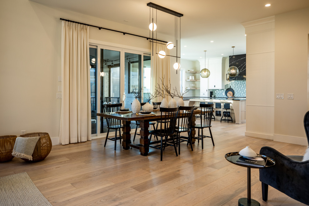 This is an example of a large country open plan dining in Calgary with white walls, plywood floors and brown floor.