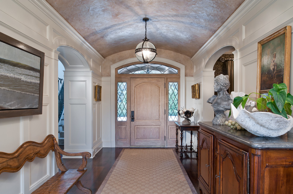 Inspiration for a large traditional foyer in New York with white walls, dark hardwood floors, a light wood front door and a single front door.