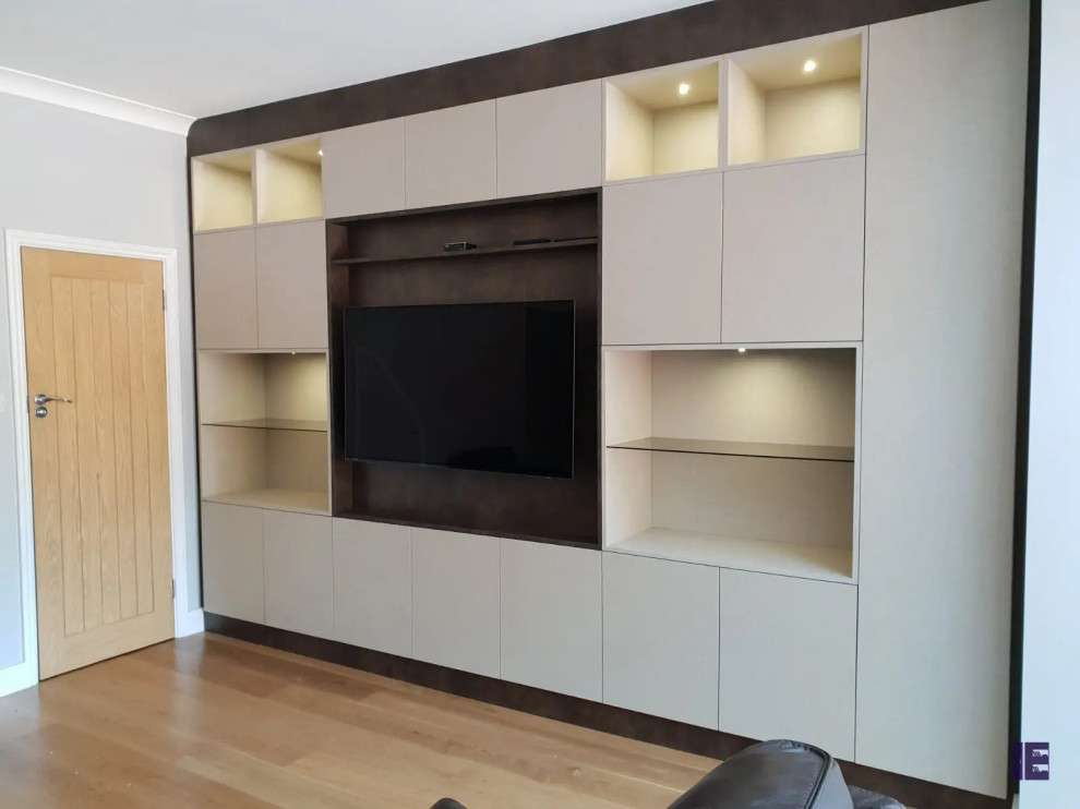 This is an example of a small contemporary storage and wardrobe in London with flat-panel cabinets, beige cabinets, plywood floors and multi-coloured floor.