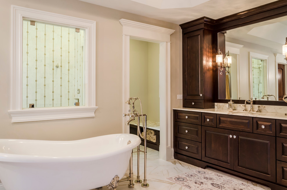 Inspiration for a large traditional master bathroom in Chicago with raised-panel cabinets, medium wood cabinets, a freestanding tub, an open shower, white tile, porcelain tile, beige walls, porcelain floors, an undermount sink, marble benchtops and a two-piece toilet.