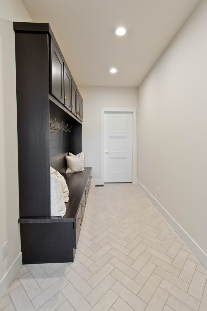Cette image montre une entrée minimaliste avec un vestiaire, un mur blanc, un sol en carrelage de porcelaine et un sol blanc.