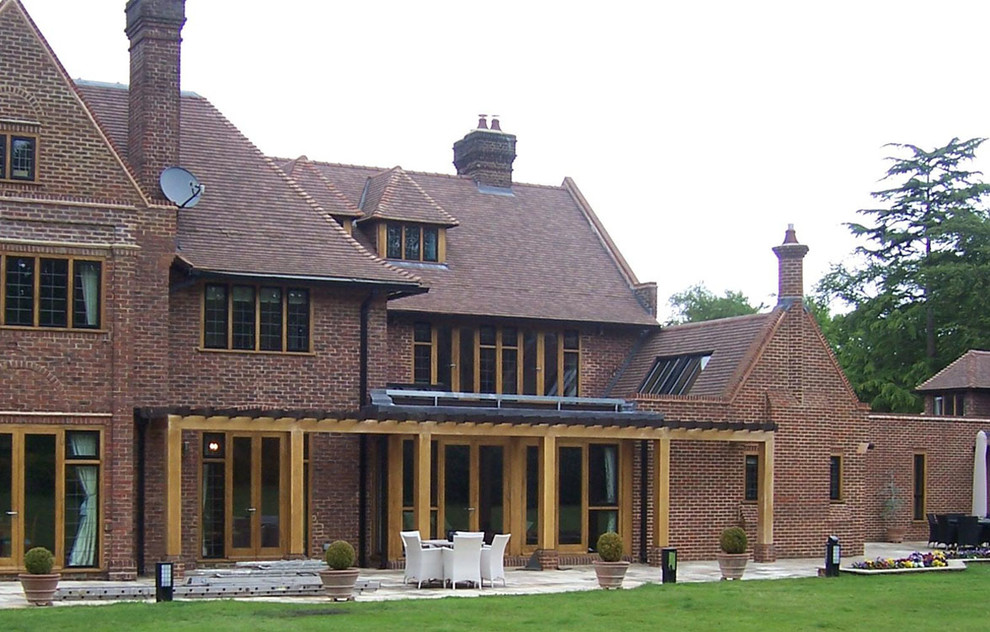 This is an example of an expansive traditional three-storey brick brown exterior in Kent with a gable roof.