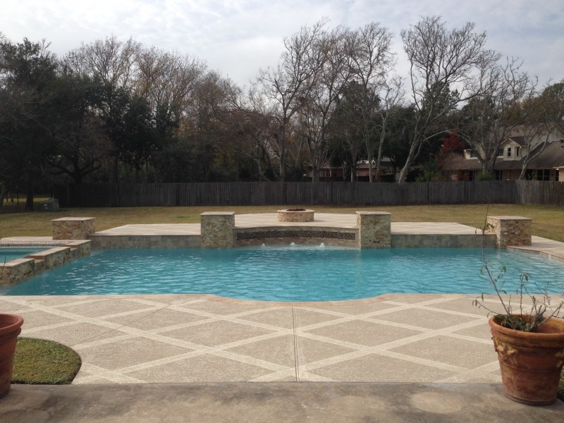 Large transitional backyard stamped concrete and custom-shaped hot tub photo in Houston
