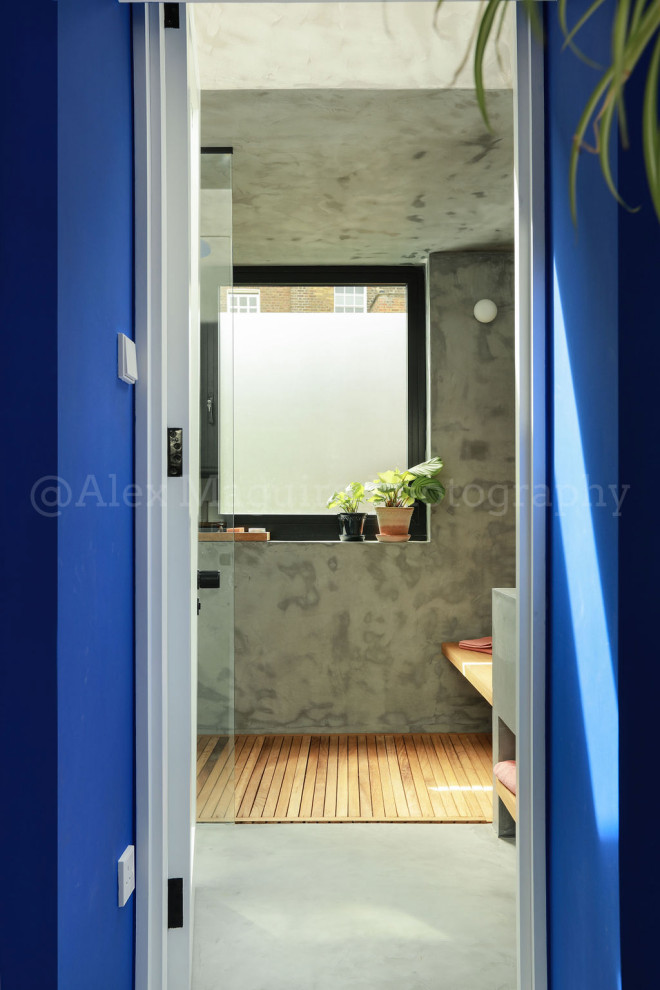 Diseño de cuarto de baño infantil y único actual de tamaño medio con ducha abierta, encimeras grises, paredes grises, lavabo integrado, suelo gris y banco de ducha