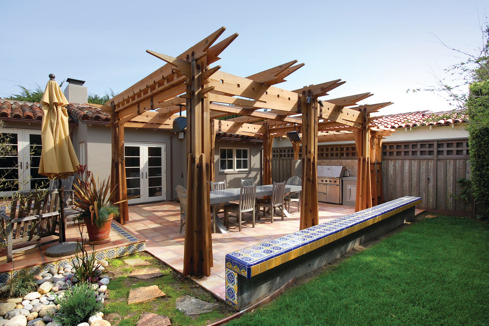 Small mediterranean backyard patio in San Francisco with tile and a pergola.
