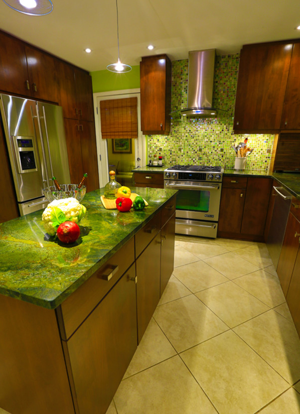 Photo of a mid-sized eclectic u-shaped kitchen in Other with an undermount sink, flat-panel cabinets, medium wood cabinets, green splashback, glass tile splashback, stainless steel appliances, ceramic floors, with island, beige floor and green benchtop.