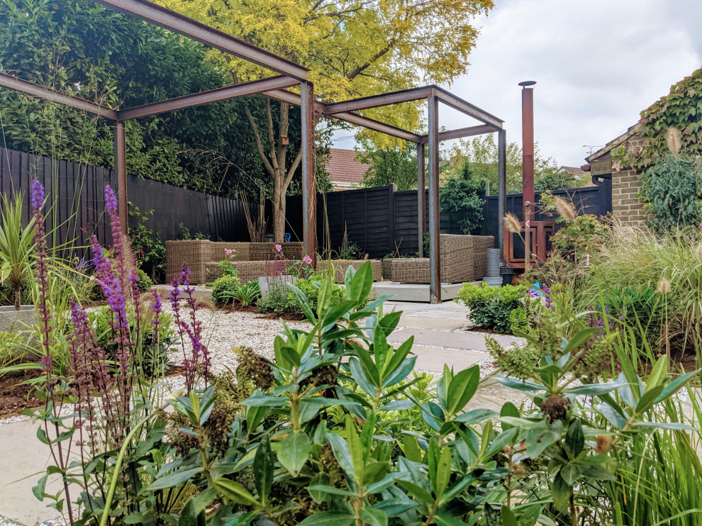 Diseño de jardín de secano contemporáneo pequeño en verano en patio trasero con pérgola, exposición parcial al sol, gravilla y con madera