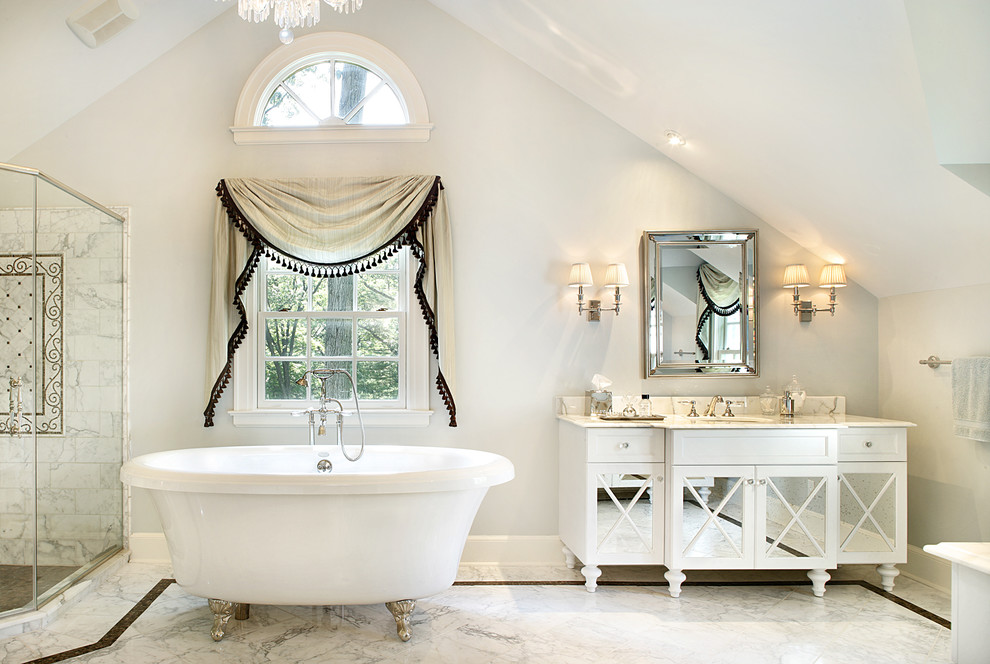Inspiration for a traditional master bathroom in New York with an undermount sink, white cabinets, marble benchtops, a claw-foot tub, white tile, stone tile, grey walls, marble floors and recessed-panel cabinets.