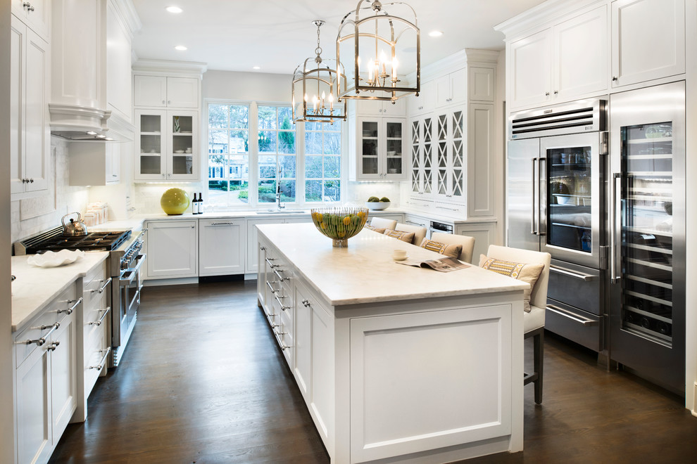 Inspiration for a large transitional l-shaped separate kitchen in Atlanta with an undermount sink, shaker cabinets, white cabinets, marble benchtops, white splashback, subway tile splashback, stainless steel appliances, dark hardwood floors, with island and brown floor.