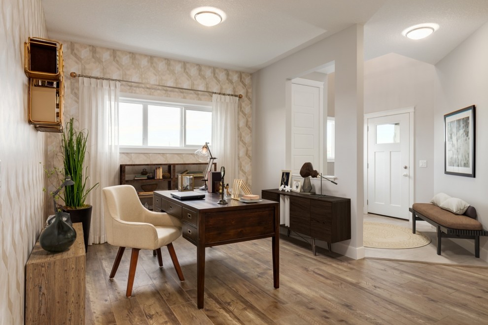Immagine di un grande ufficio contemporaneo con pareti beige, pavimento in laminato, scrivania autoportante e pavimento marrone