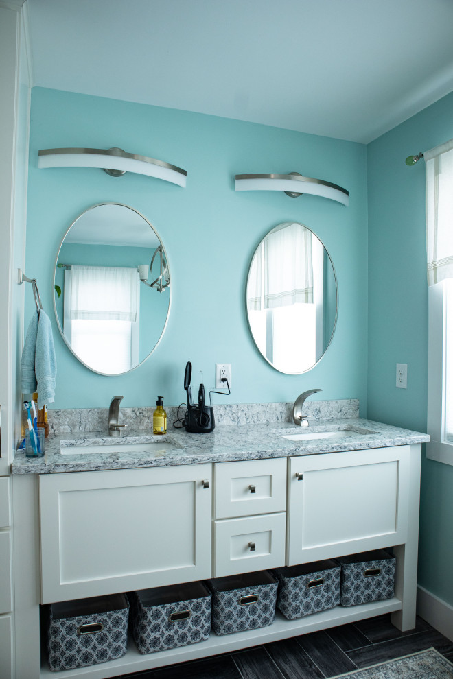 Example of a large beach style master ceramic tile, brown floor and double-sink bathroom design in Other with recessed-panel cabinets, white cabinets, blue walls, an undermount sink, quartz countertops, gray countertops and a freestanding vanity