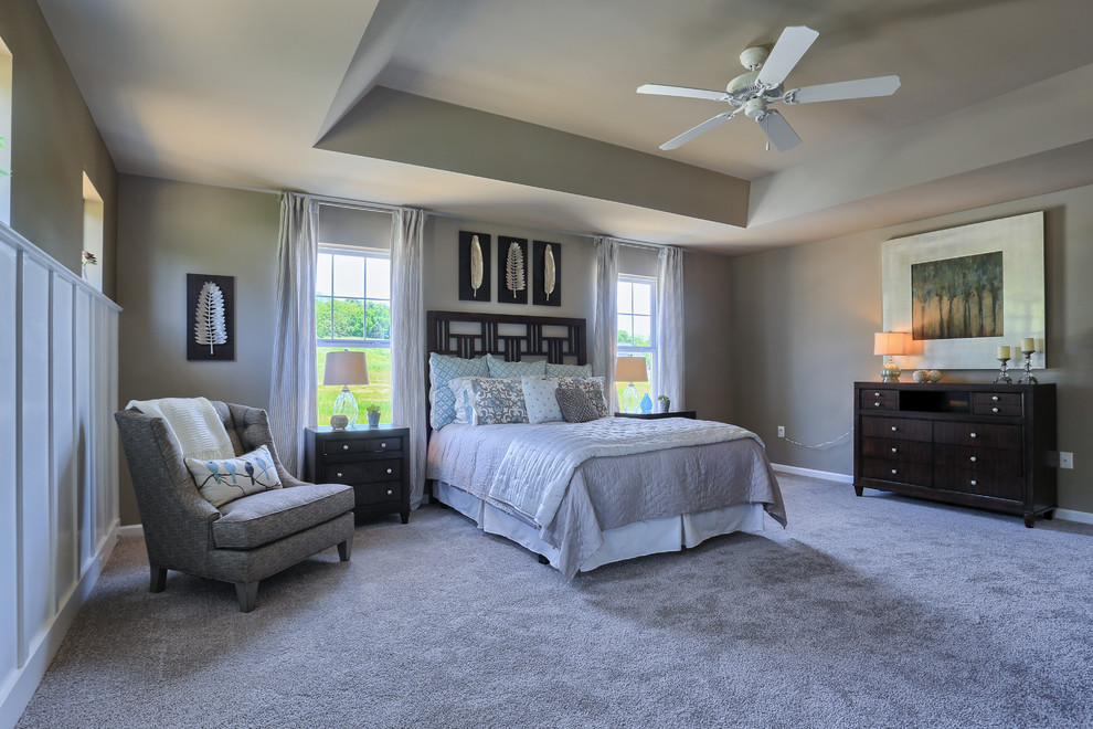 This is an example of an expansive traditional master bedroom in Philadelphia with beige walls and carpet.
