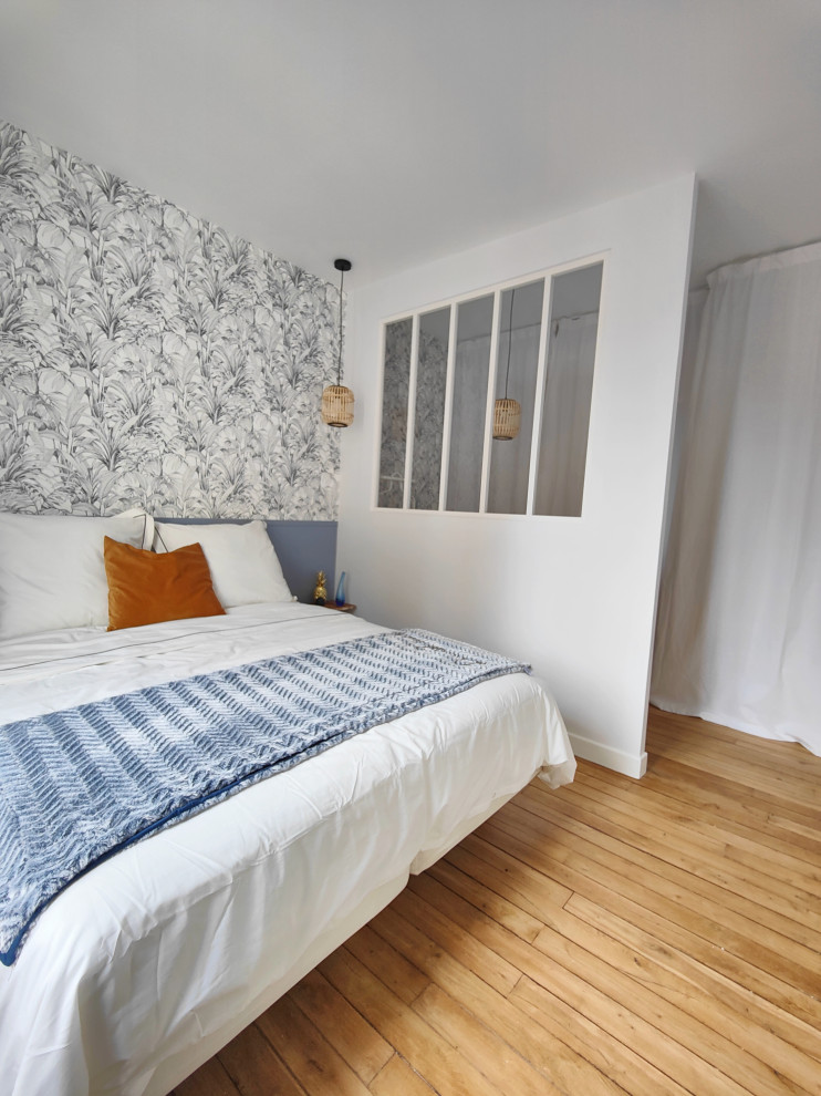 Mittelgroßes Nordisches Hauptschlafzimmer mit blauer Wandfarbe, hellem Holzboden und Tapetenwänden in Paris