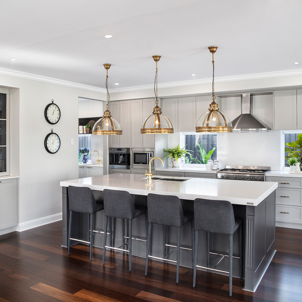 Inspiration for a beach style kitchen in Brisbane with a double-bowl sink, shaker cabinets, grey cabinets, white splashback, stainless steel appliances, dark hardwood floors, with island, brown floor and white benchtop.