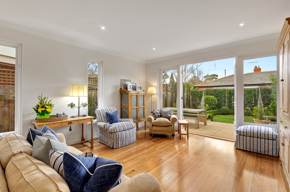 Mid-sized traditional open concept family room in Melbourne with medium hardwood floors.
