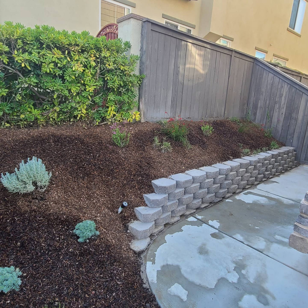 This is an example of a mid-sized transitional front yard partial sun xeriscape for summer in San Diego with a garden path and natural stone pavers.