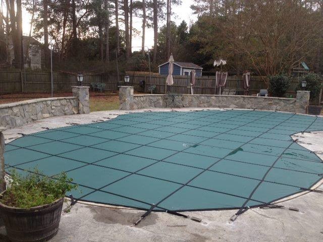 Example of a backyard stamped concrete and kidney-shaped pool design
