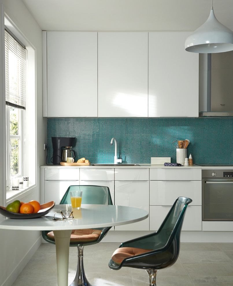 Inspiration for a mid-sized contemporary single-wall eat-in kitchen in Lille with a drop-in sink, white cabinets, blue splashback, stainless steel appliances, ceramic floors and no island.