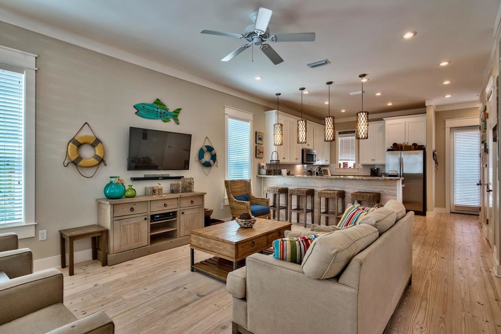 Photo of a beach style open concept family room in Miami with grey walls, light hardwood floors and a wall-mounted tv.