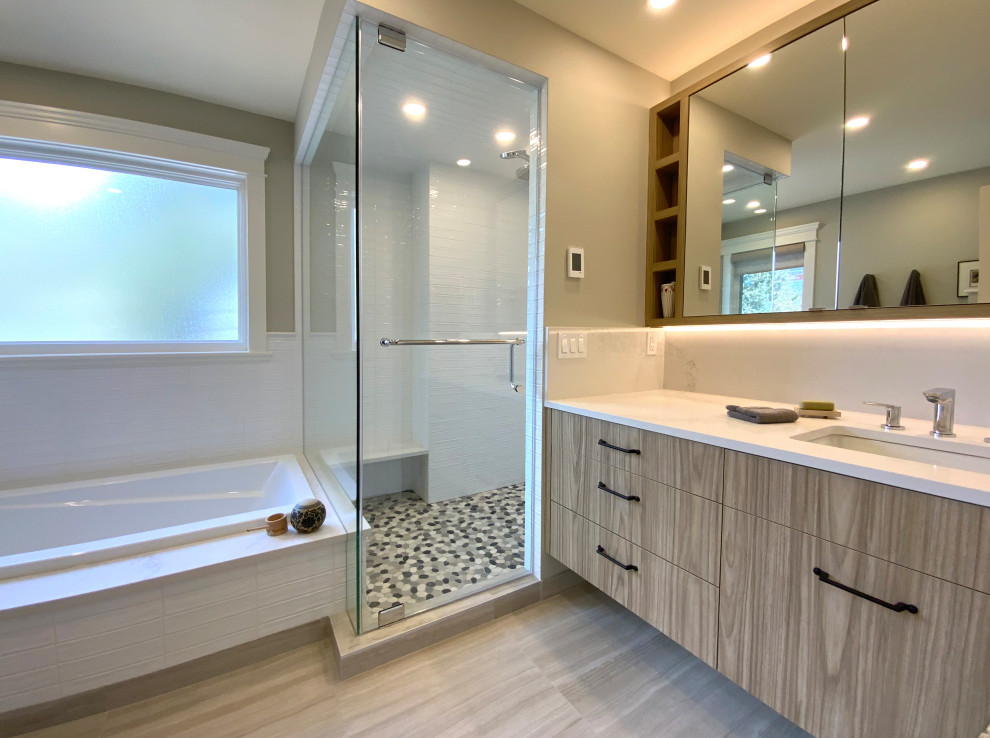 Photo of a mid-sized contemporary master bathroom in Calgary with flat-panel cabinets, light wood cabinets, a drop-in tub, a corner shower, a two-piece toilet, white tile, ceramic tile, green walls, porcelain floors, an undermount sink, engineered quartz benchtops, a hinged shower door, white benchtops, a shower seat, a single vanity, a floating vanity and decorative wall panelling.