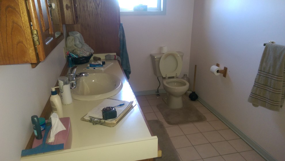 Mid-sized transitional master vinyl floor and multicolored floor alcove bathtub photo with recessed-panel cabinets, medium tone wood cabinets, a two-piece toilet, gray walls, laminate countertops and yellow countertops