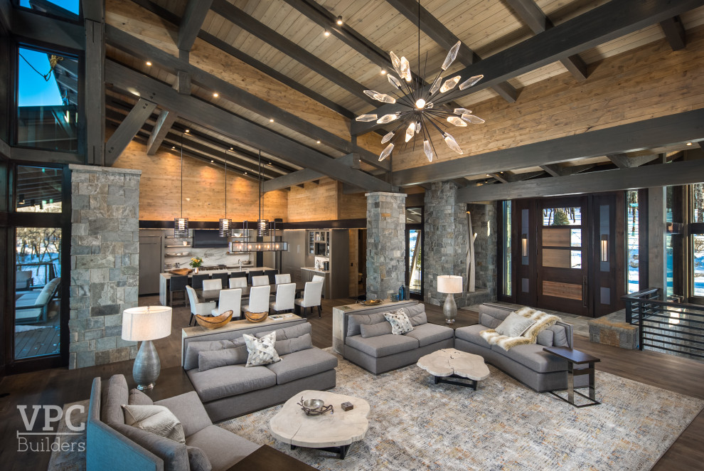 Inspiration for an expansive contemporary formal open plan living room in Charlotte with brown walls, medium hardwood flooring, a standard fireplace, a wooden fireplace surround, a freestanding tv, brown floors, a wood ceiling and wood walls.