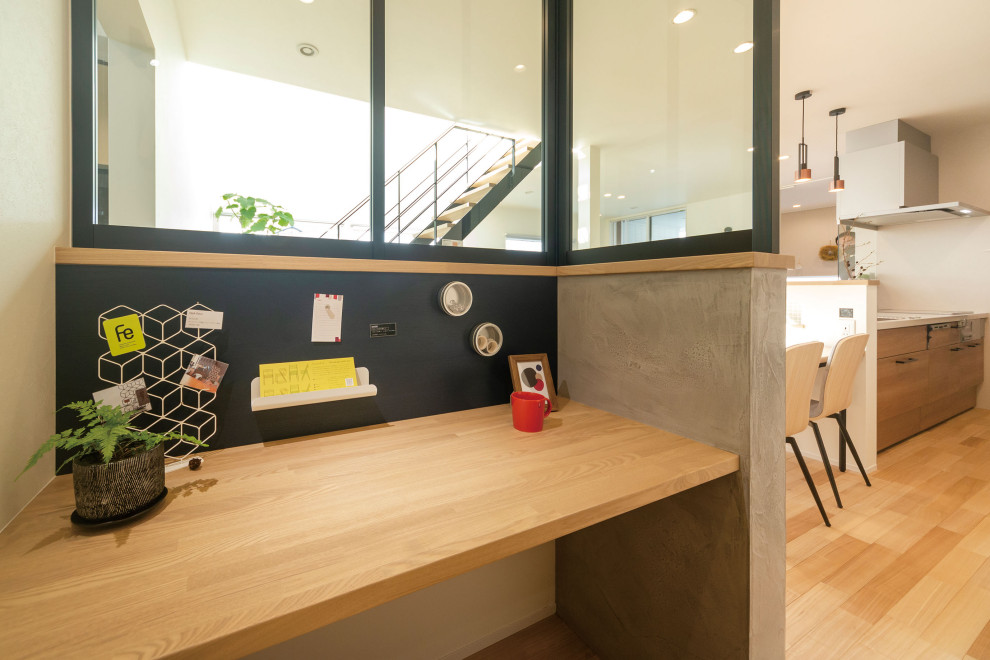 Imagen de despacho moderno con paredes multicolor, suelo de madera en tonos medios y escritorio empotrado