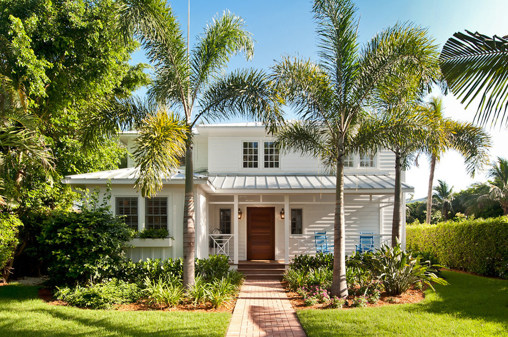 Inspiration for a beach style two-storey white exterior in Miami with mixed siding and a hip roof.