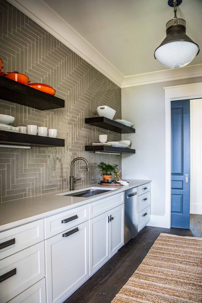 Inspiration for a dark wood floor and brown floor eat-in kitchen remodel with a farmhouse sink, shaker cabinets, white cabinets, marble backsplash, stainless steel appliances and an island