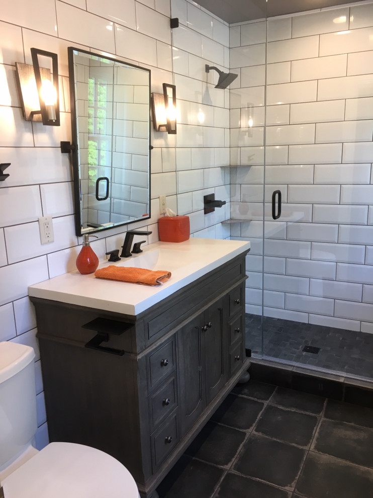 Photo of a small eclectic kids bathroom in St Louis with beaded inset cabinets, distressed cabinets, an open shower, a two-piece toilet, white tile, subway tile, grey walls, porcelain floors, an integrated sink, concrete benchtops, black floor, a hinged shower door and white benchtops.