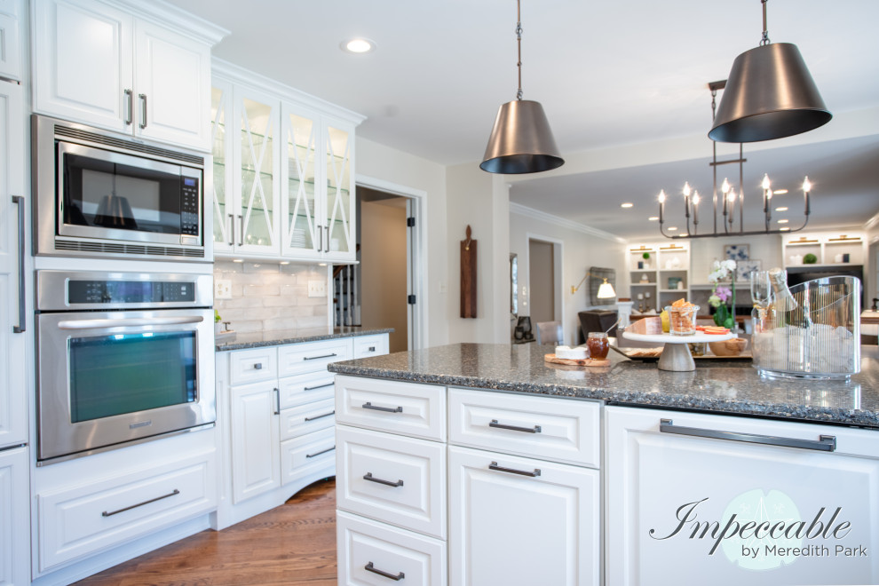 Large transitional u-shaped medium tone wood floor and brown floor eat-in kitchen photo in Chicago with an undermount sink, raised-panel cabinets, white cabinets, quartz countertops, beige backsplash, subway tile backsplash, paneled appliances, a peninsula and multicolored countertops