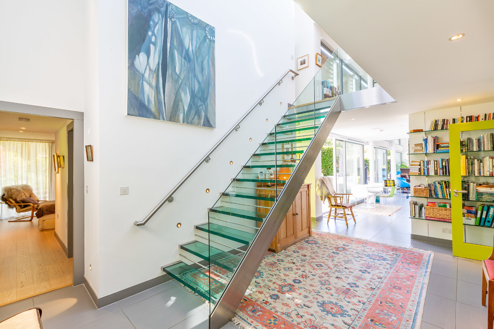 This is an example of a contemporary glass straight staircase in Other with open risers and glass railing.