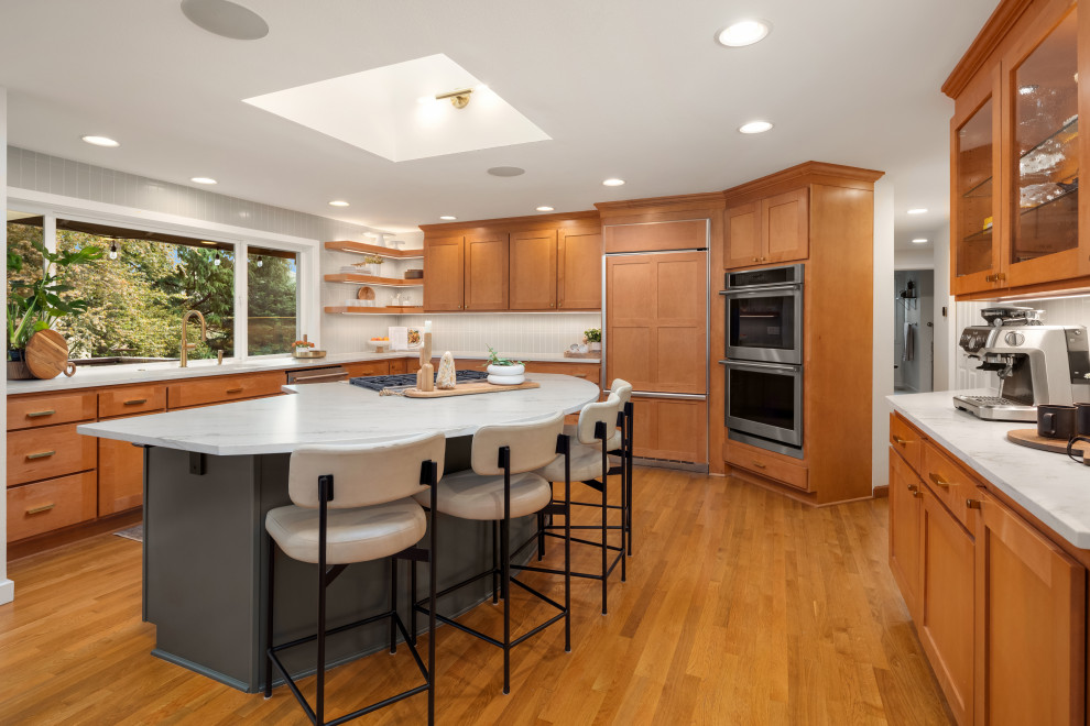 Foto på ett 60 tals vit kök med öppen planlösning, med en undermonterad diskho, släta luckor, skåp i mellenmörkt trä, bänkskiva i kvartsit, grått stänkskydd, stänkskydd i keramik, rostfria vitvaror, mellanmörkt trägolv och en köksö