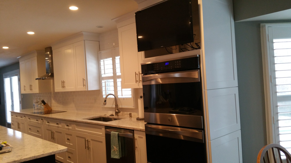 Transitional galley eat-in kitchen photo with an undermount sink, shaker cabinets, white cabinets, marble countertops, white backsplash, subway tile backsplash, stainless steel appliances, an island and gray countertops