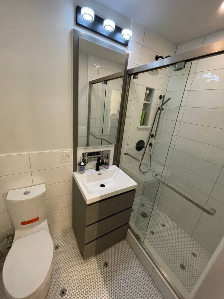 Example of a mid-sized trendy 3/4 white tile and ceramic tile mosaic tile floor, white floor and single-sink bathroom design in New York with a one-piece toilet, white walls, a drop-in sink, white countertops, a niche and a freestanding vanity