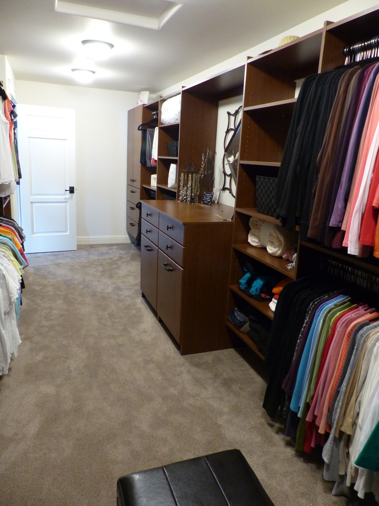 Expansive contemporary gender-neutral walk-in wardrobe in Seattle with raised-panel cabinets and medium wood cabinets.