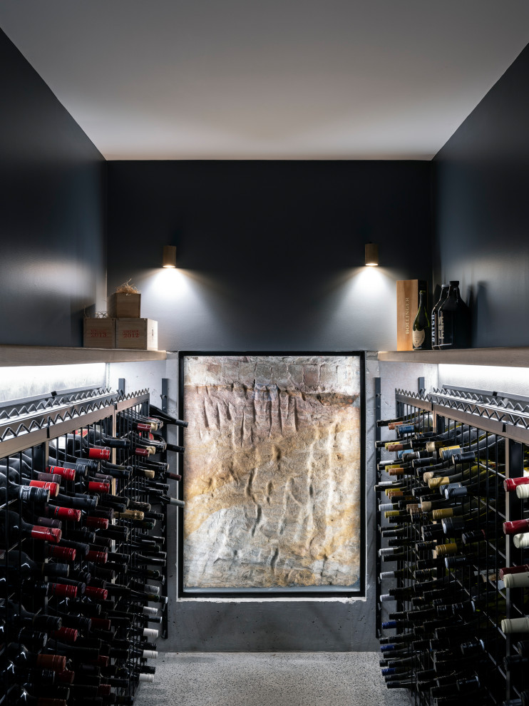 Contemporary wine cellar in Sydney with concrete floors and storage racks.